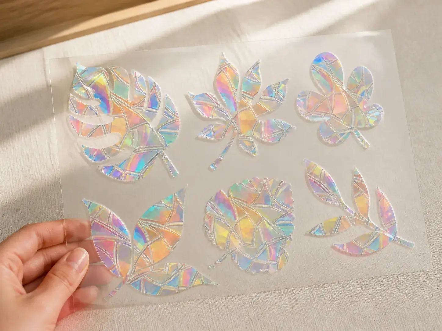 Hand holding one translucent prismatic window form to show its scale